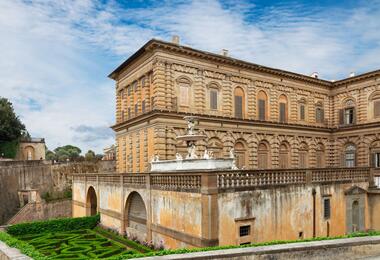 Scenic view of the Boboli Gardens with the Viceroy's Palace in the background, showcasing lush greenery and elegant architecture.
