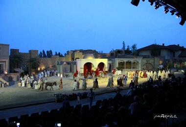 A stage scene from the Sordevolo Passion Play featuring actors in costumes and horses.