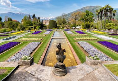 A garden statue surrounded by colourful blooms at Villa Taranto, showcasing the serene landscape.