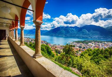 Scenic view of a lake and mountains from an old building, showcasing natural beauty and historic architecture.