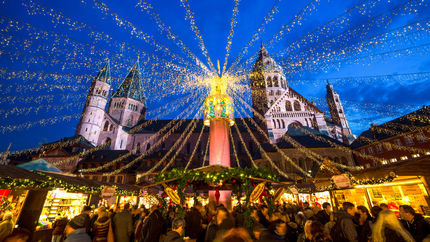A bustling Christmas market in Bavaria, Germany, featuring festive lights, stalls, and visitors enjoying seasonal treats.