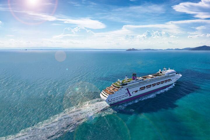 A majestic cruise ship navigates the vast ocean, surrounded by calm waters and distant horizons.