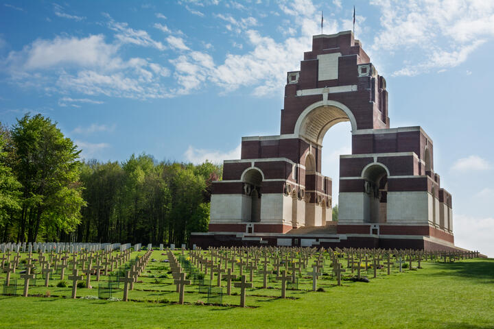 Monument honoring fallen soldiers, standing solemnly at the battlefield's edge, surrounded by greenery and remembrance.
