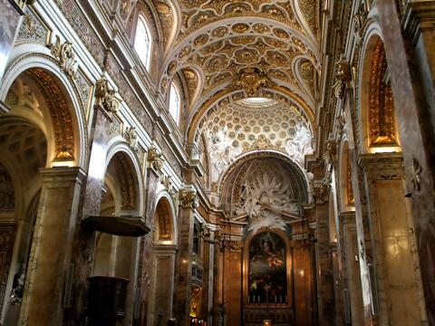 Ornate church interior featuring intricate ceilings and detailed wall decorations, showcasing architectural beauty.