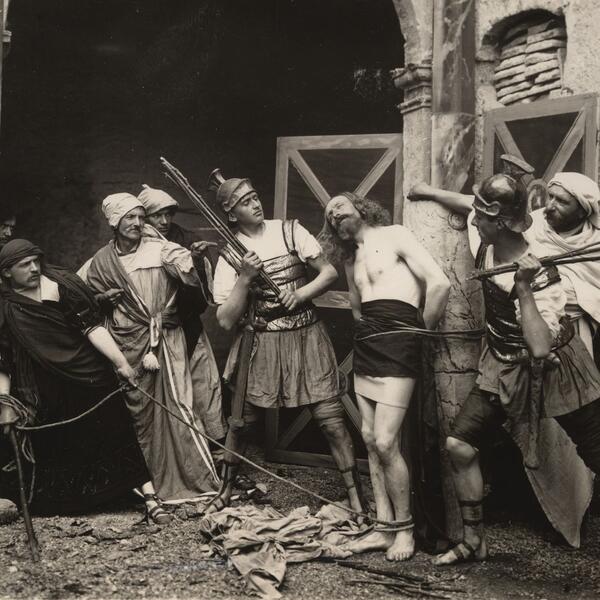 A group of actors in costumes, holding spears, performing in the Sordevolo Passion Play.