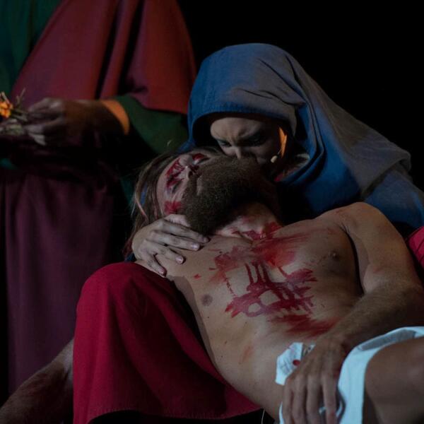 In the Sordevolo Passion Play, Jesus is on the ground, accompanied by a woman and a man, conveying a scene of sorrow.