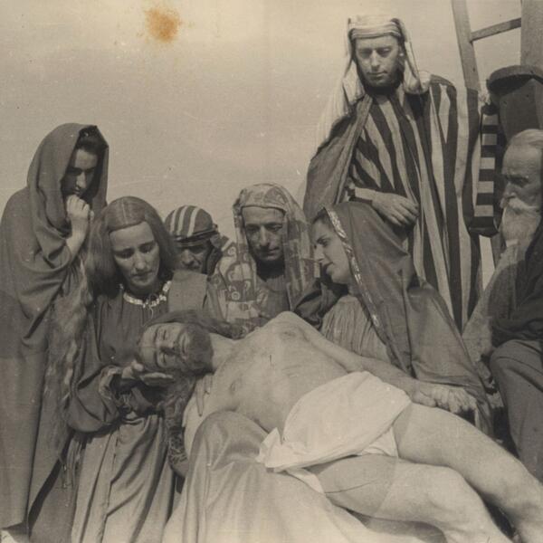 A group of people gathered around Jesus lying on the ground, depicting a scene from the Sordevolo Passion Play.