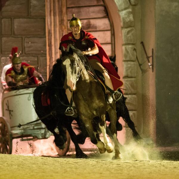 A scene from the Sordevolo Passion Play featuring a group of people riding horses in period costumes.