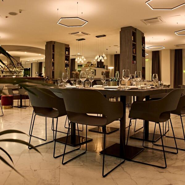 Dining area at Hotel Agora Palace with neatly set tables and chairs positioned centrally in the restaurant.