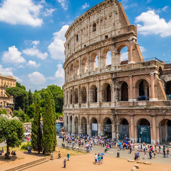 The Colosseum in Rome, Italy, showcasing its iconic arches and ancient stone structure against a clear blue sky.