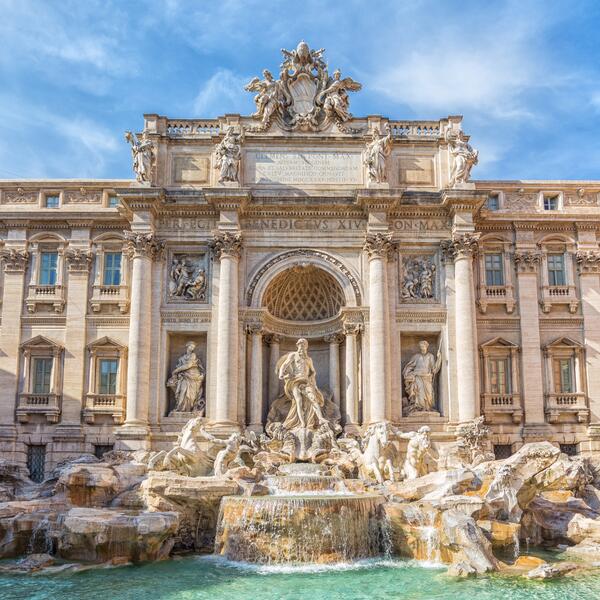 Trevi Fountain in Rome, Italy, showcasing its ornate sculptures and flowing water under a clear blue sky.