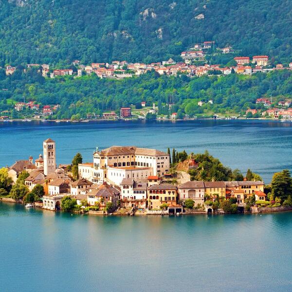 Aerial view of an island featuring a quaint town surrounded by the serene waters of Lake Orta.