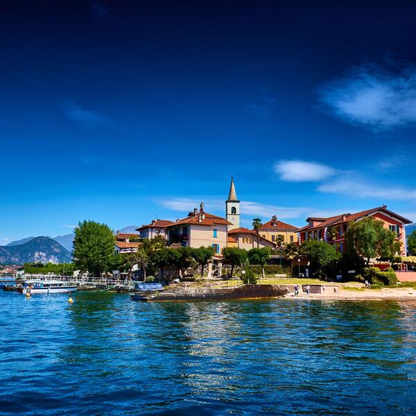  Scenic view of an island with a quaint church, set against a backdrop of vibrant blue water and greenery.