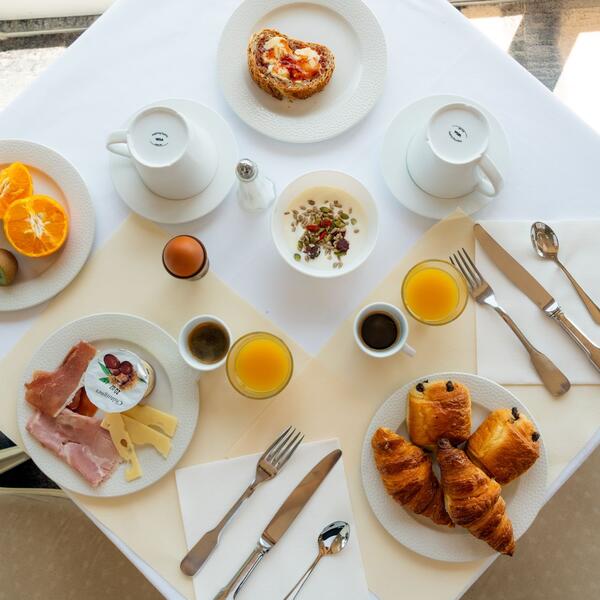 A table set with a variety of breakfast items, including pastries, fruits, and beverages.
