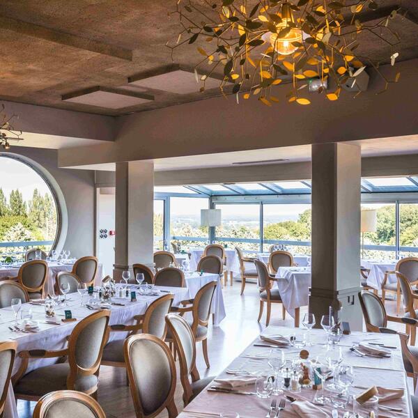 Elegant restaurant interior with tables and chairs arranged for an evening dinner service.