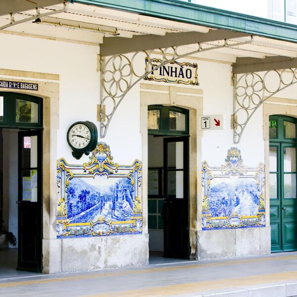 A train station featuring intricate blue and white tile work on the walls, creating a vibrant and artistic atmosphere.