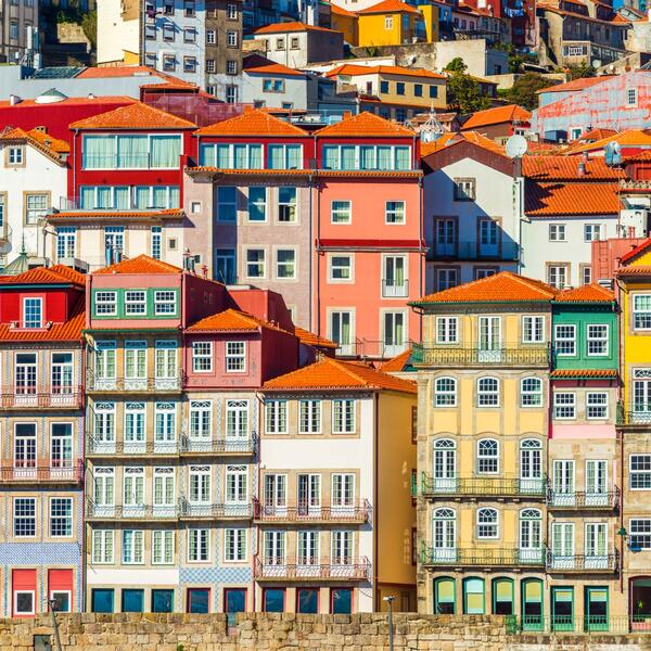 A scenic view of Porto, Portugal, showcasing its historic architecture and the Douro River under a clear blue sky.