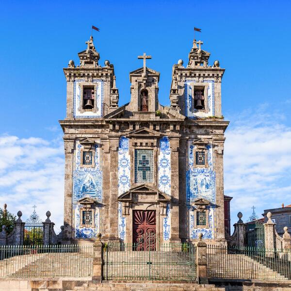 The Church of Santo Amaro in Porto, Portugal, features intricate architecture and a vibrant blue sky in the background.