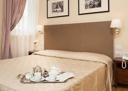 Classic hotel room at Hotel Executive, Florence, featuring a neatly made bed and elegant decor.